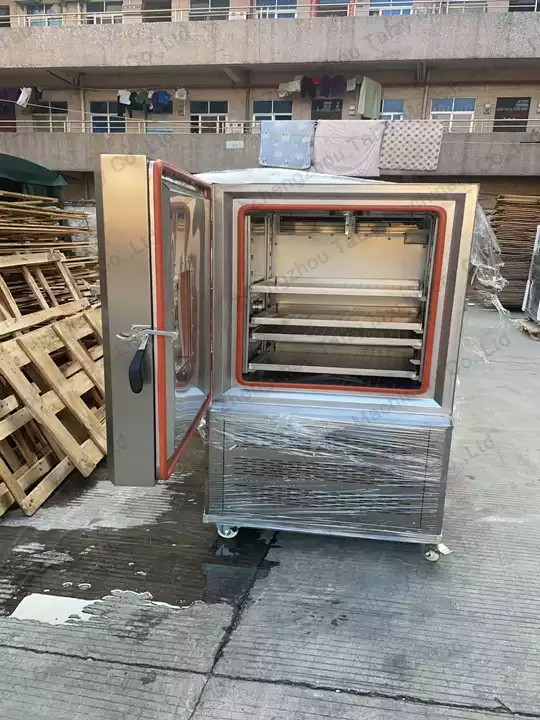 Open door of the black garlic machine revealing internal stainless trays